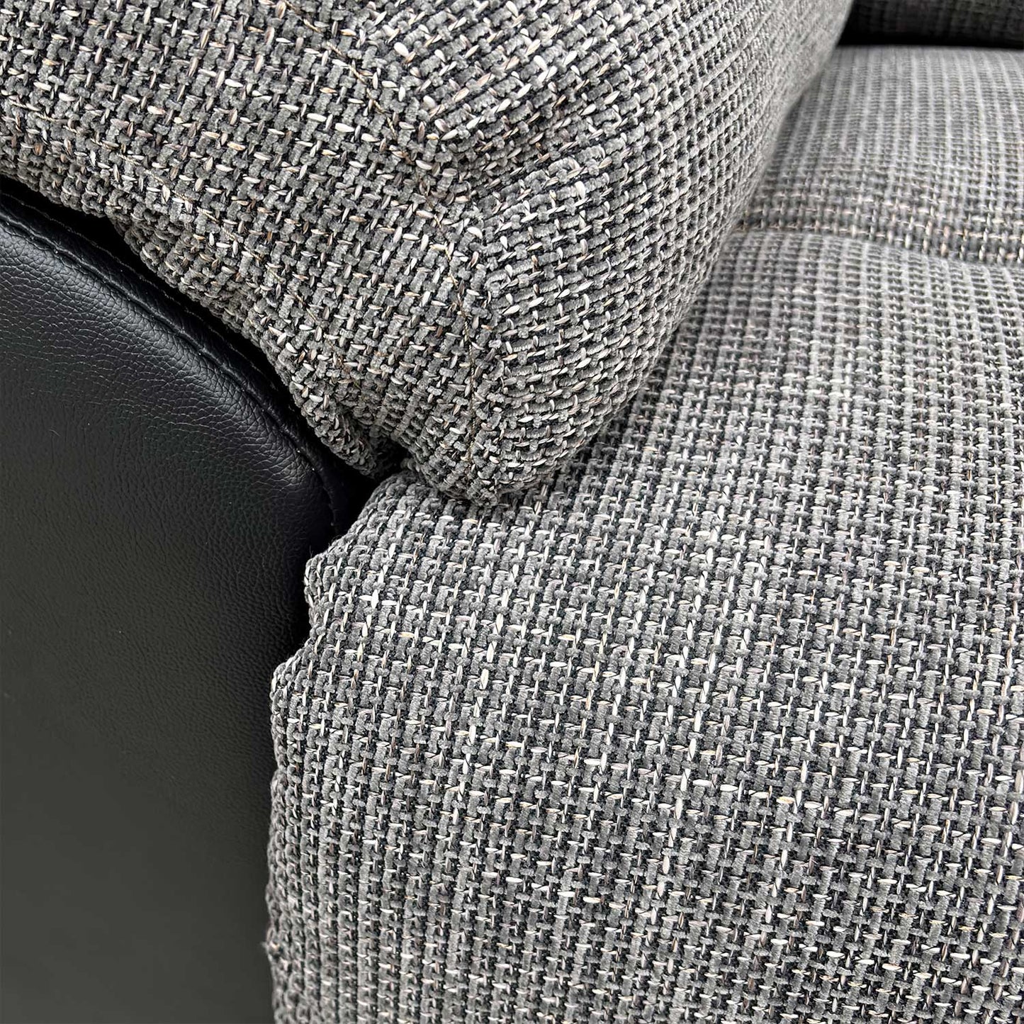 Close-up of the durable charcoal fabric upholstery and stitched detailing.