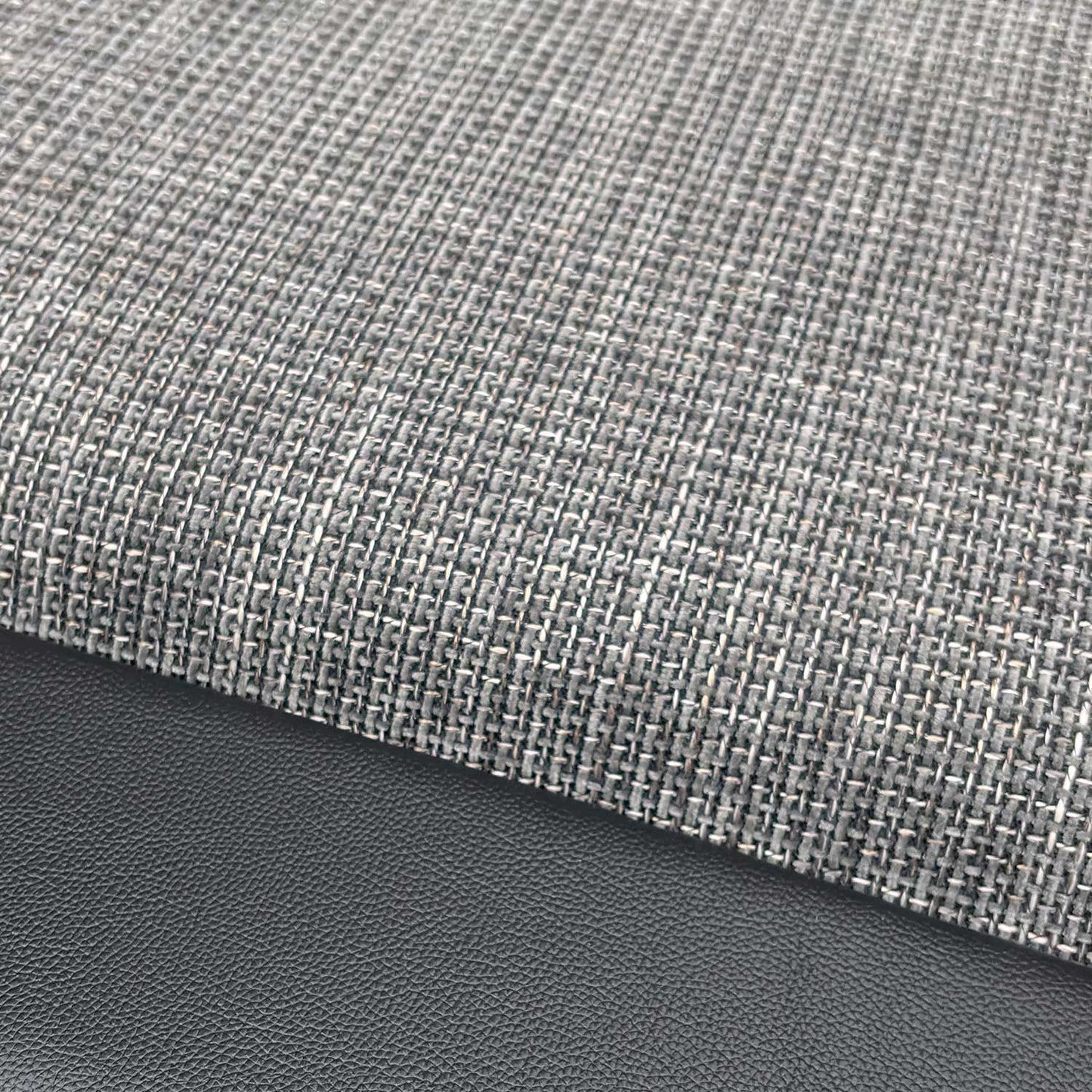 Close-up of the durable charcoal fabric upholstery and stitched detailing.