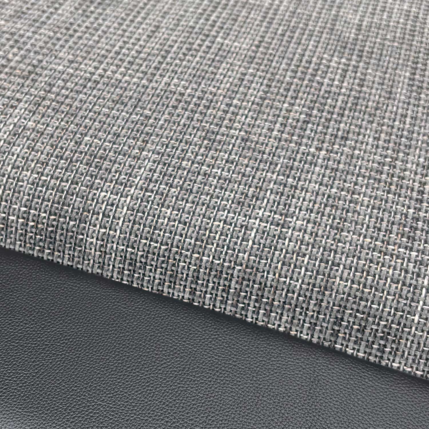 Close-up of the durable charcoal fabric upholstery and stitched detailing.