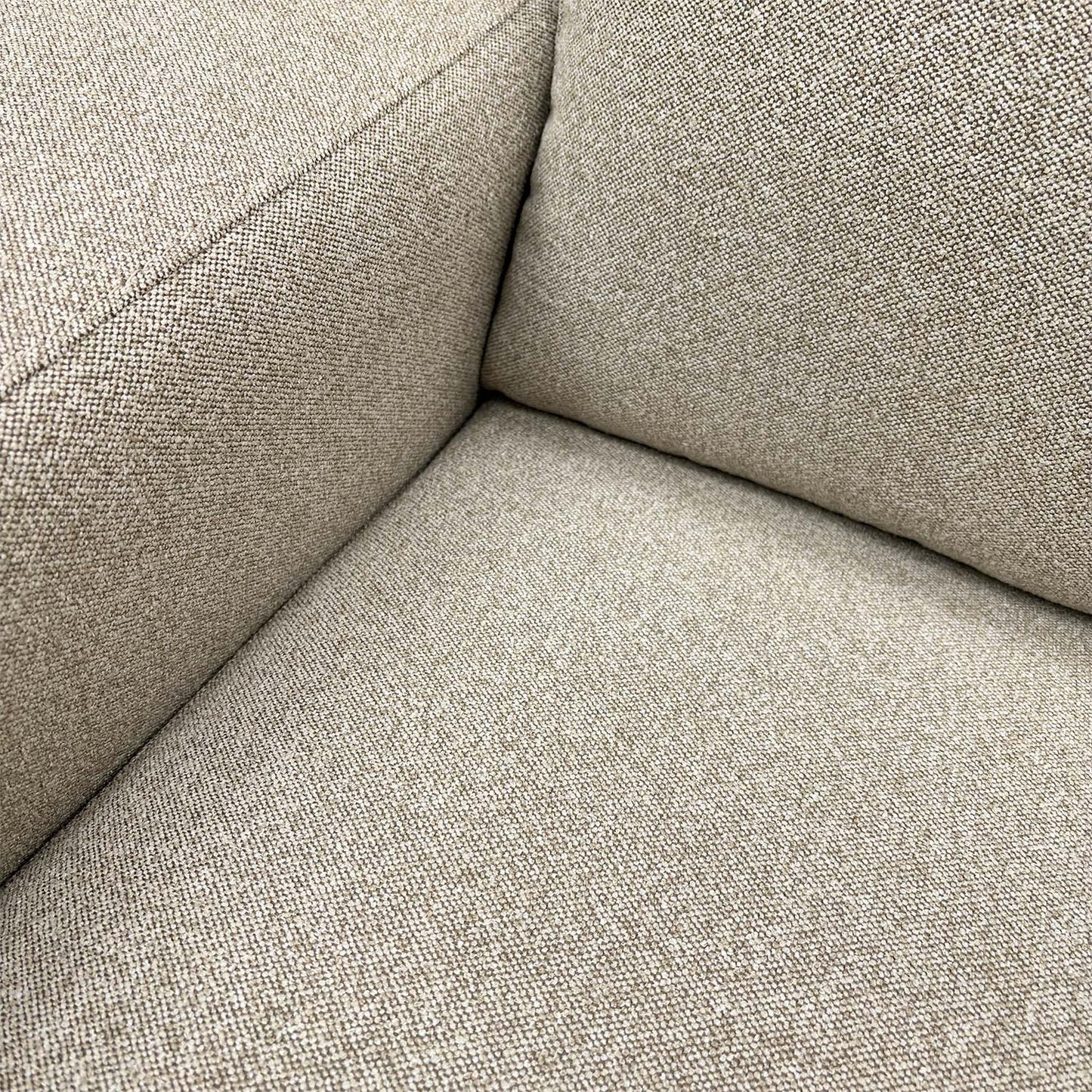 Detailed close-up of the natural fabric upholstery on the ‘Cortes’ armchair, illustrating the soft weave and quality finish.