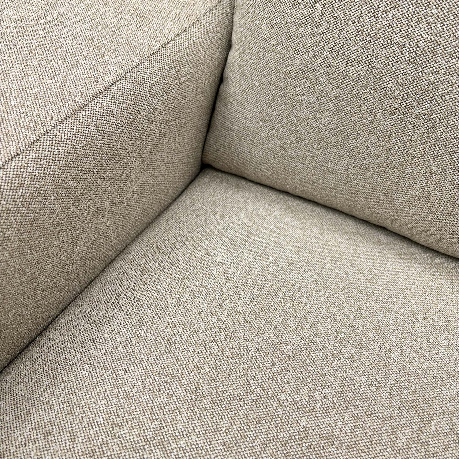 Detailed close-up of the natural fabric upholstery on the ‘Cortes’ armchair, illustrating the soft weave and quality finish.