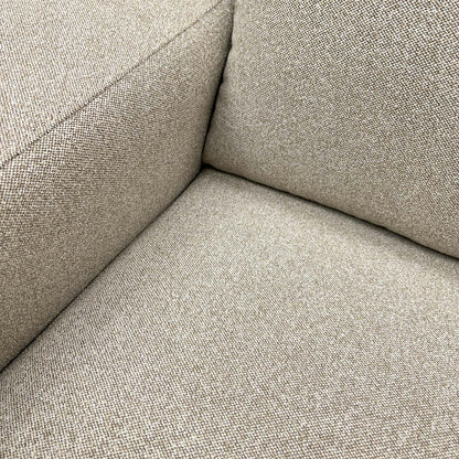 Detailed close-up of the natural fabric upholstery on the ‘Cortes’ armchair, illustrating the soft weave and quality finish.