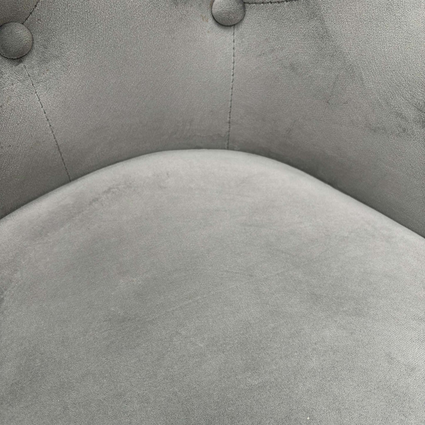 Close-up of the plush grey velvet upholstery and precision button-tufting craftsmanship.