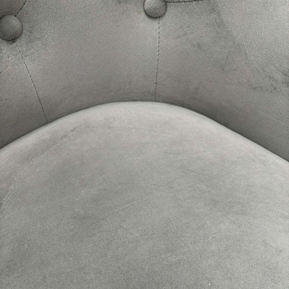 Close-up of the plush grey velvet upholstery and precision button-tufting craftsmanship.