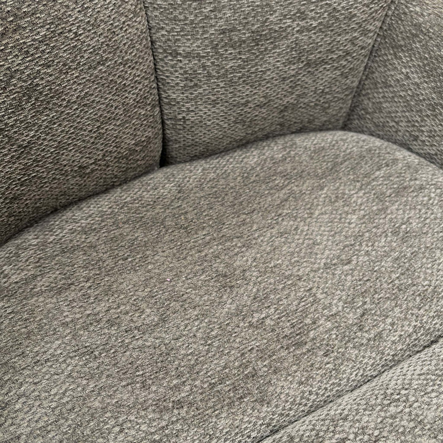 Detailed shot of the premium ash grey textured upholstery fabric and high-quality stitching.