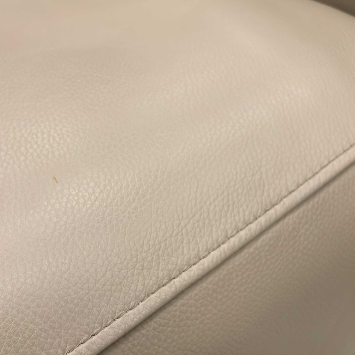 Close-up of the seating area and armrest, highlighting the premium stitching and build quality of the Furniture Village piece.