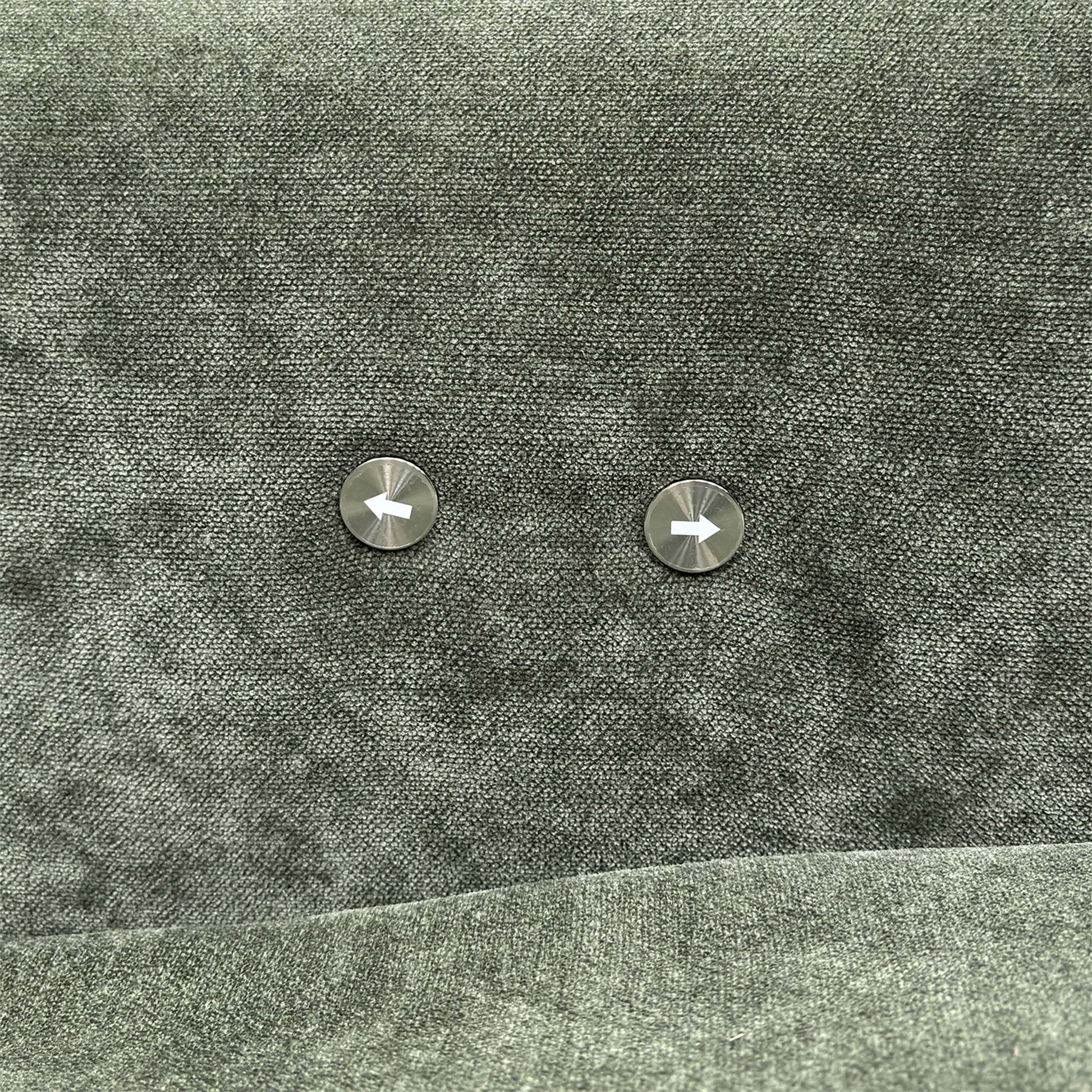 Close-up of the power recliner controls located on the side of the forest green fabric arm.