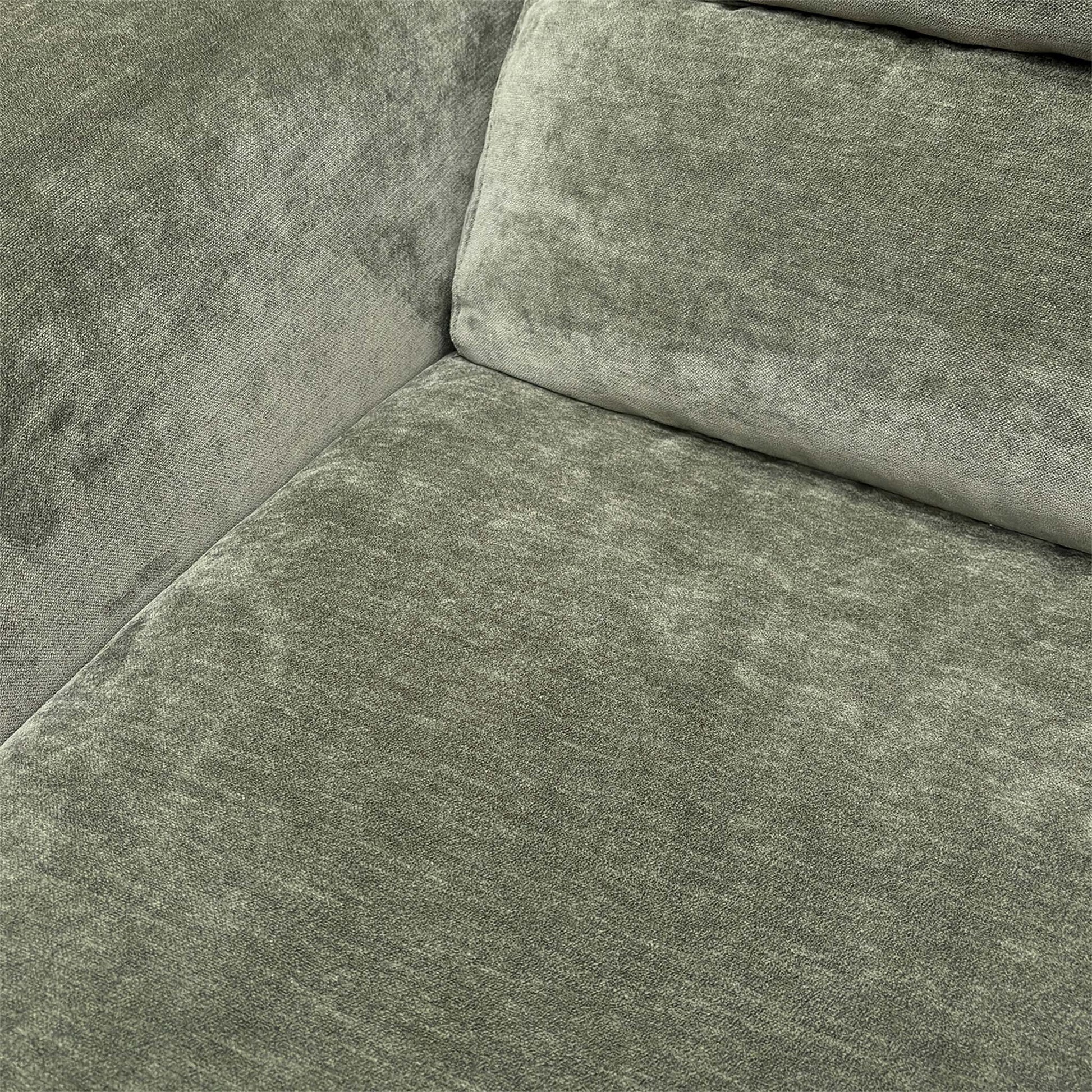 Detailed shot of the plush forest green upholstery fabric and durable stitched seams.
