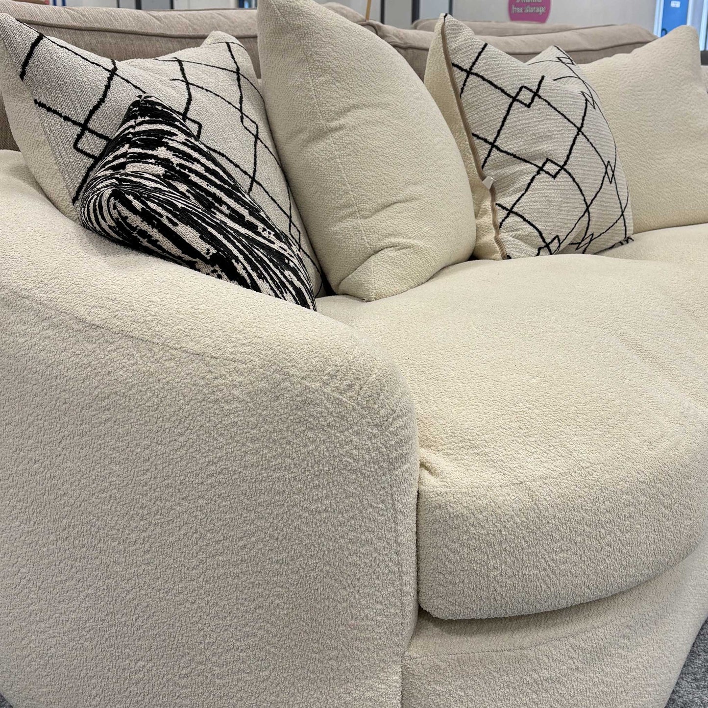 Side profile of the ‘Bow’ sofa emphasizing the rounded armrests and seamless boucle upholstery.