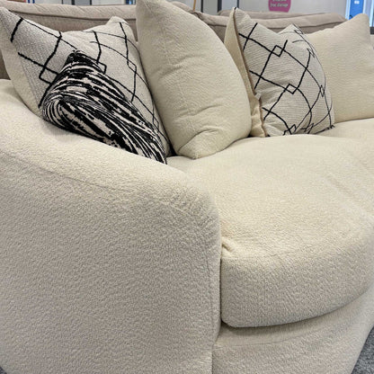 Side profile of the ‘Bow’ sofa emphasizing the rounded armrests and seamless boucle upholstery.