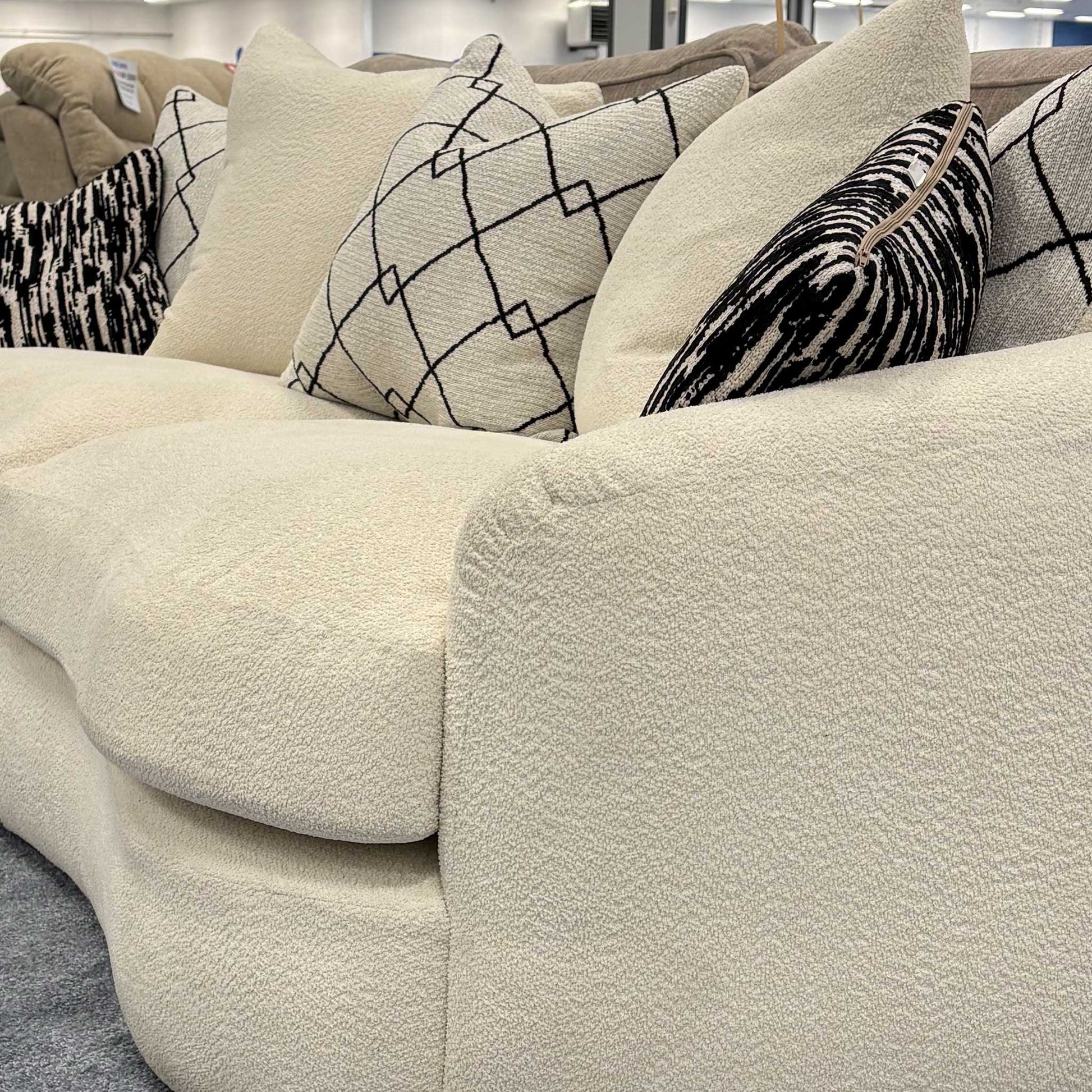 Side profile of the ‘Bow’ sofa emphasizing the rounded armrests and seamless boucle upholstery.
