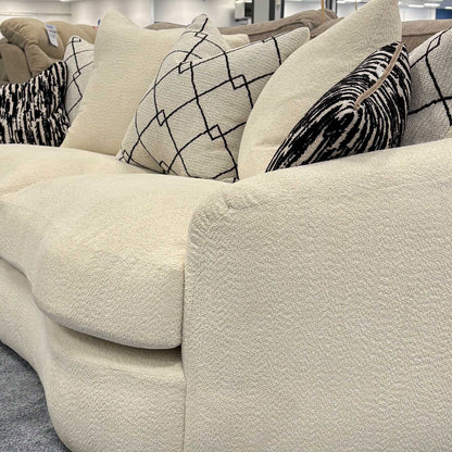 Side profile of the ‘Bow’ sofa emphasizing the rounded armrests and seamless boucle upholstery.