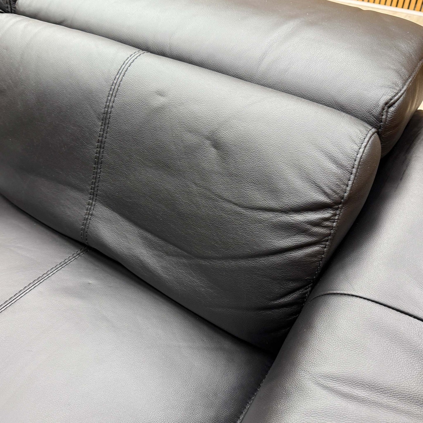 Detailed shot of the premium black leather upholstery texture and high-quality stitched seam finishes.