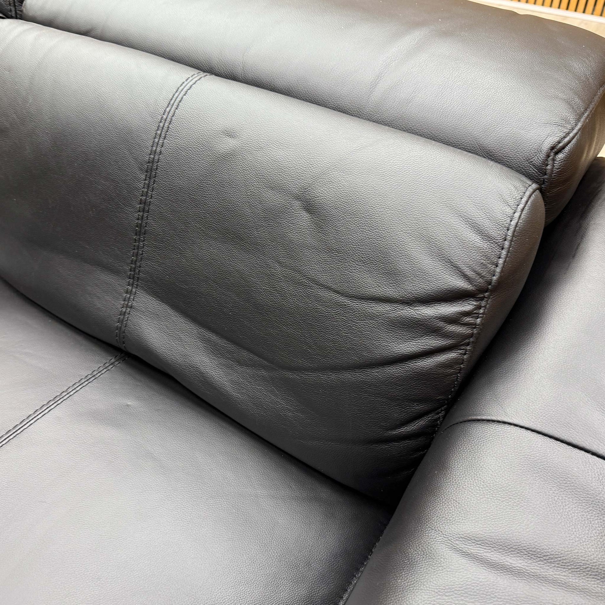 Detailed shot of the premium black leather upholstery texture and high-quality stitched seam finishes.