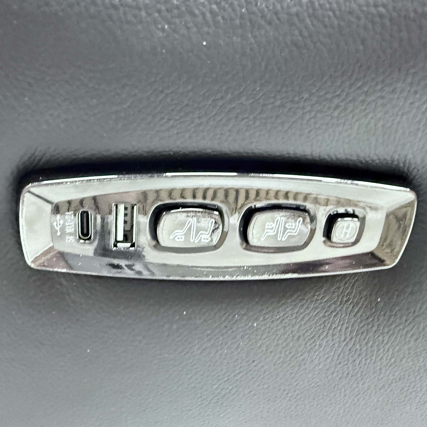 Close-up of the sleek integrated power control buttons and USB charging port on the side of the ‘Xavier’ sofa.