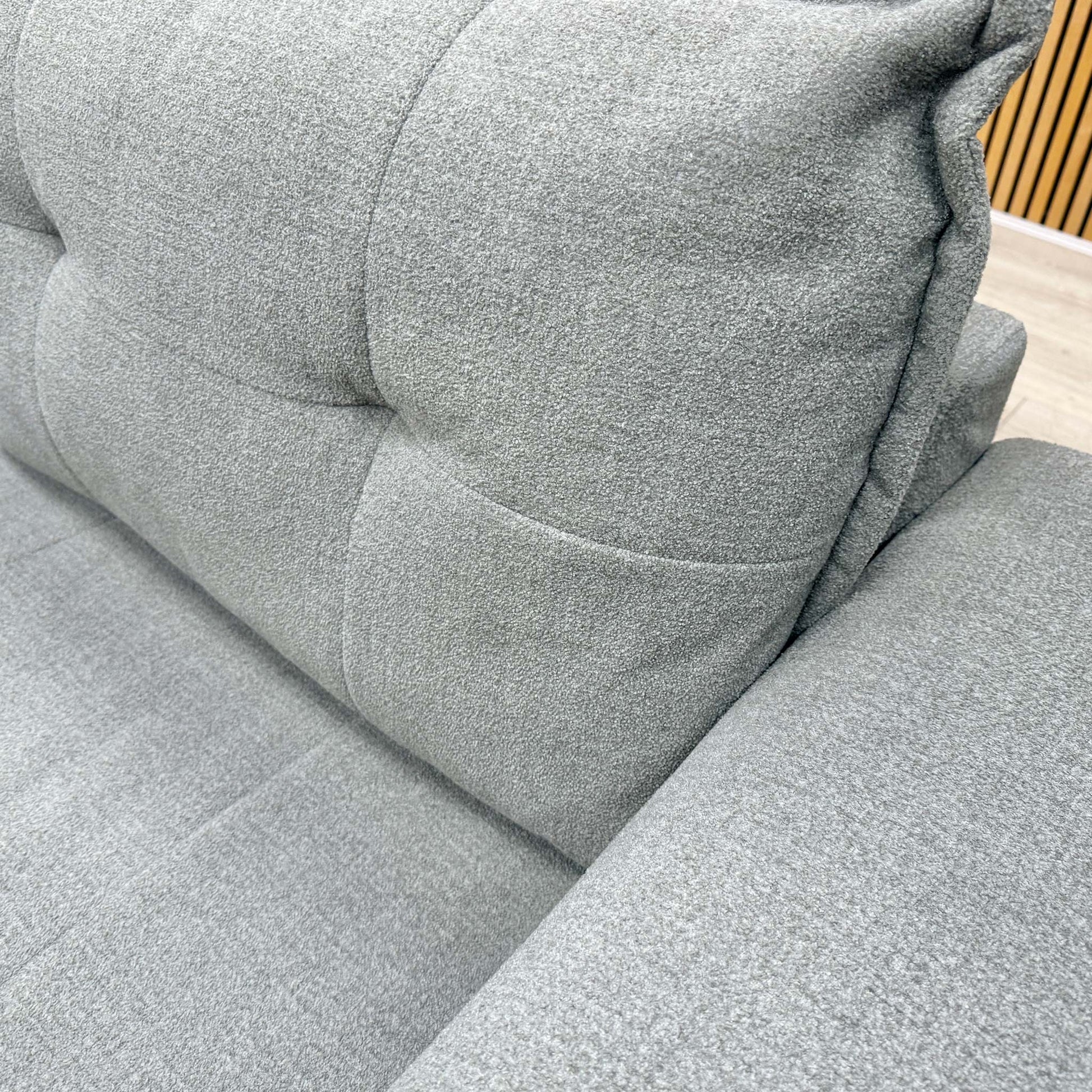 Close-up of the modern button-tufted upholstery and textured Oxford Grey fabric on the Goliath sofa.