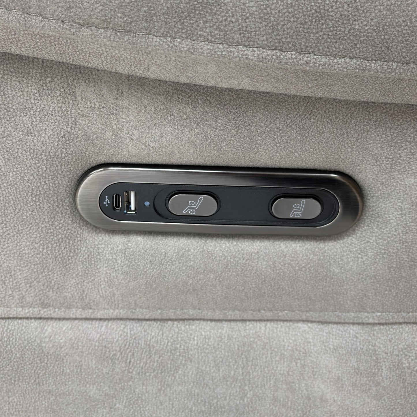 Close-up of the integrated chrome power reclining controls located on the side of the velvet armrest.