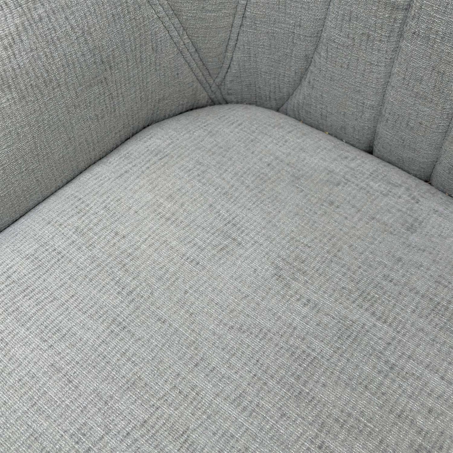 Close-up of the vertical fluted stitching and premium silver fabric upholstery on the chair back.