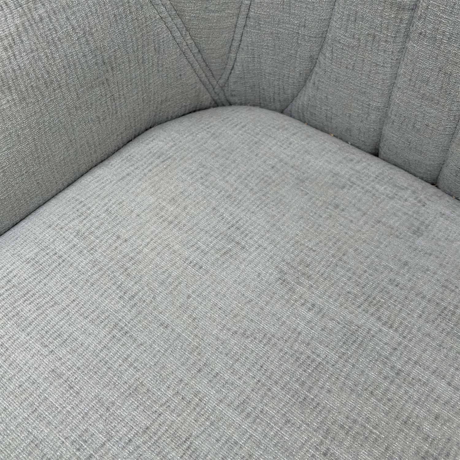 Close-up of the vertical fluted stitching and premium silver fabric upholstery on the chair back.