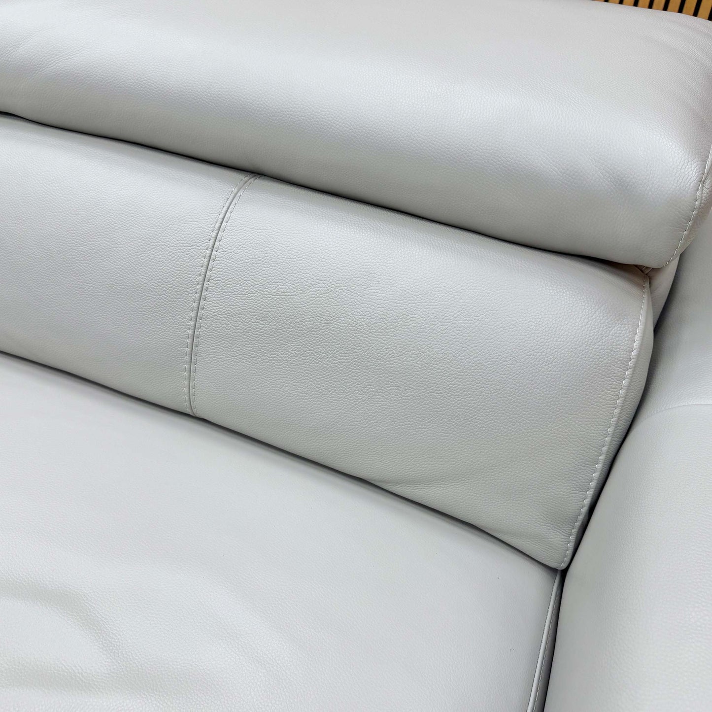 Close-up detail of the premium grey leather upholstery and refined stitching on the ‘Infinity’ sofa frame.