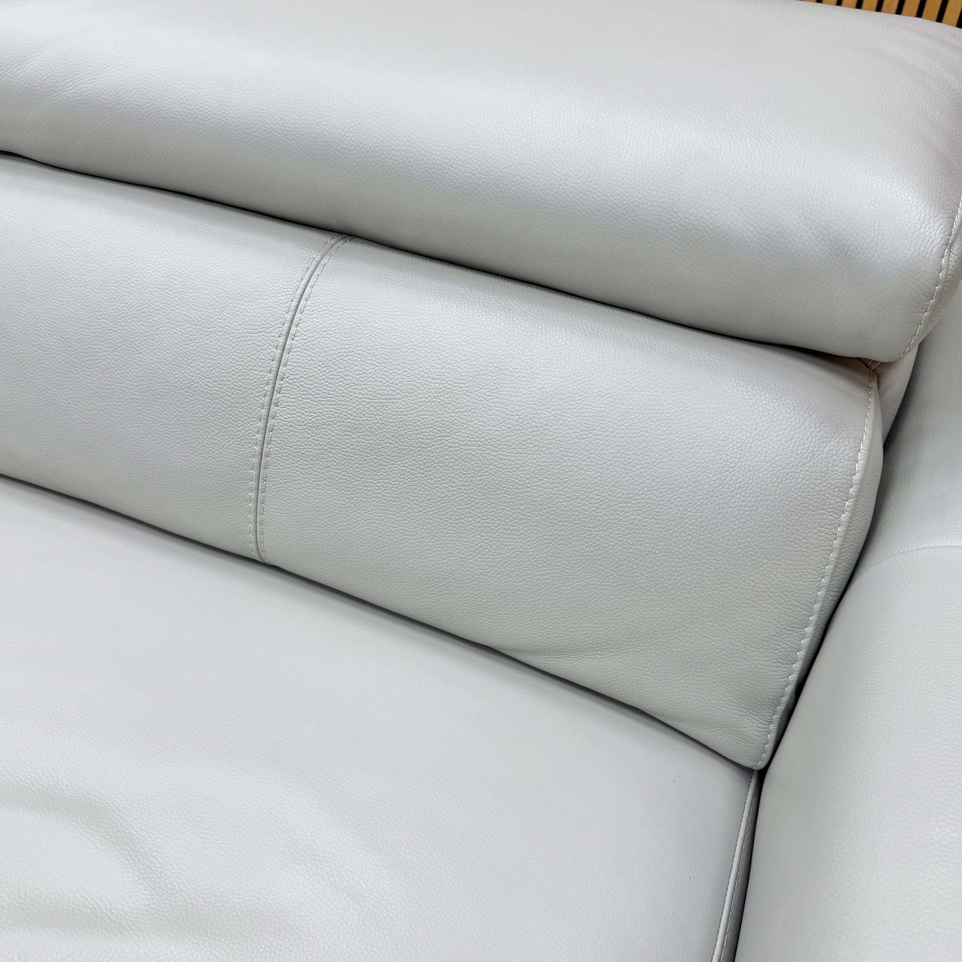 Close-up detail of the premium grey leather upholstery and refined stitching on the ‘Infinity’ sofa frame.
