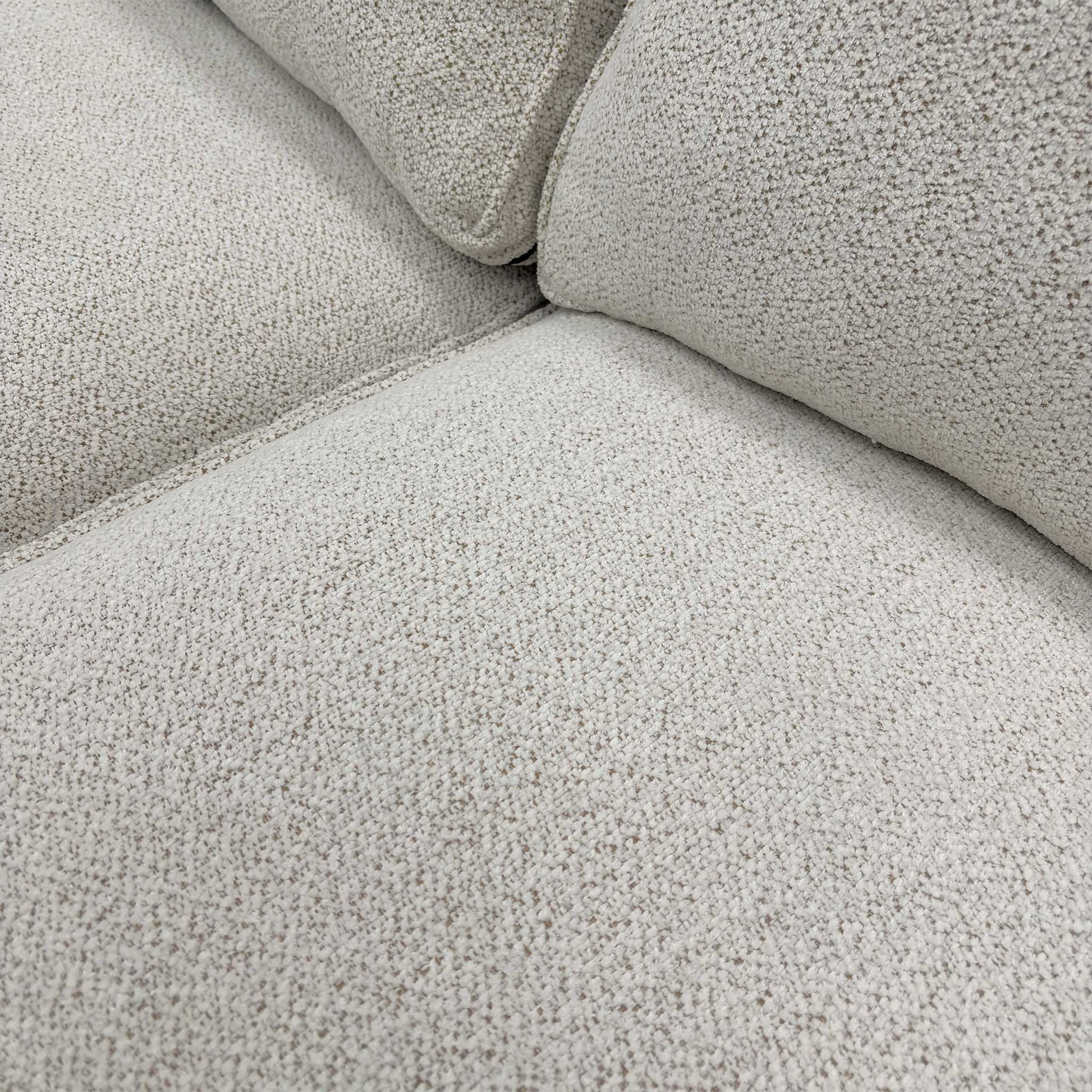 Close-up of the high-quality beige soft woven upholstery fabric and textured weave detail.