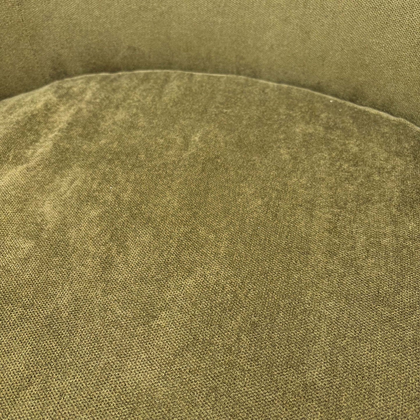 Close-up of the high-quality sage green fabric and durable upholstery stitching on the ‘Terry’ chair.