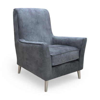 Side view of the ‘Collins’ infinity velvet chair, highlighting the elegant slope of the armrests and supportive back.