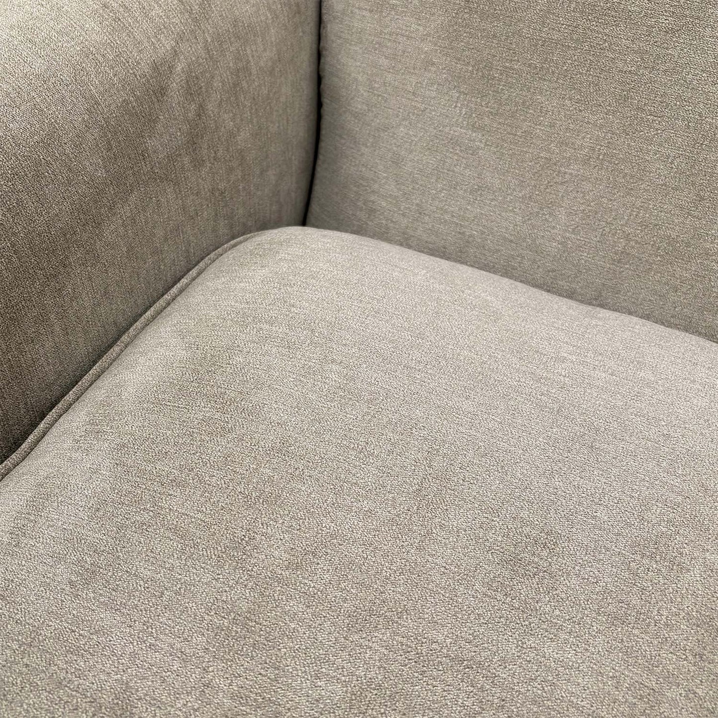 Close-up shot of the soft grey upholstery fabric, emphasizing the high-quality weave and texture.