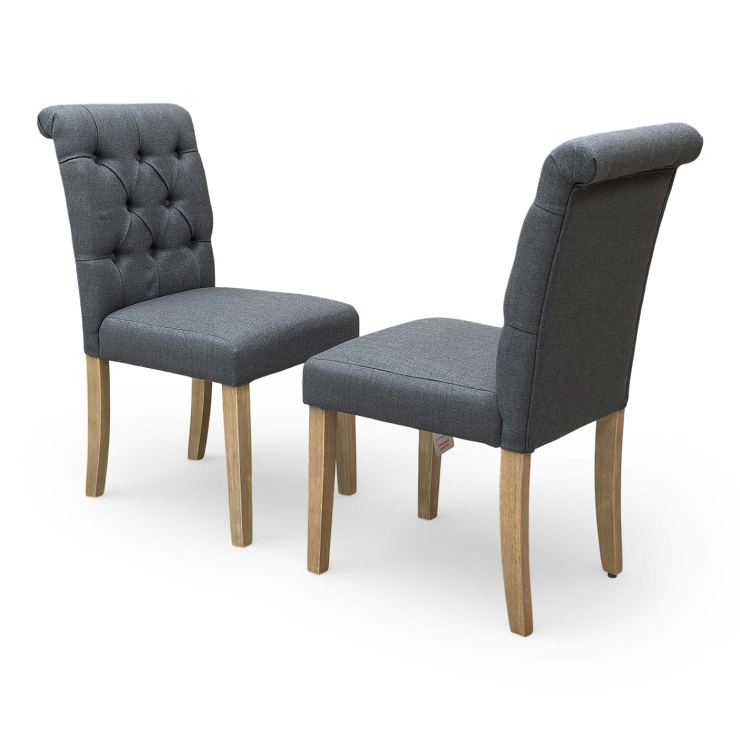 Full view of the ‘Lewis’ set of 2 anthracite fabric dining chairs with button-back detailing and dark wood legs.