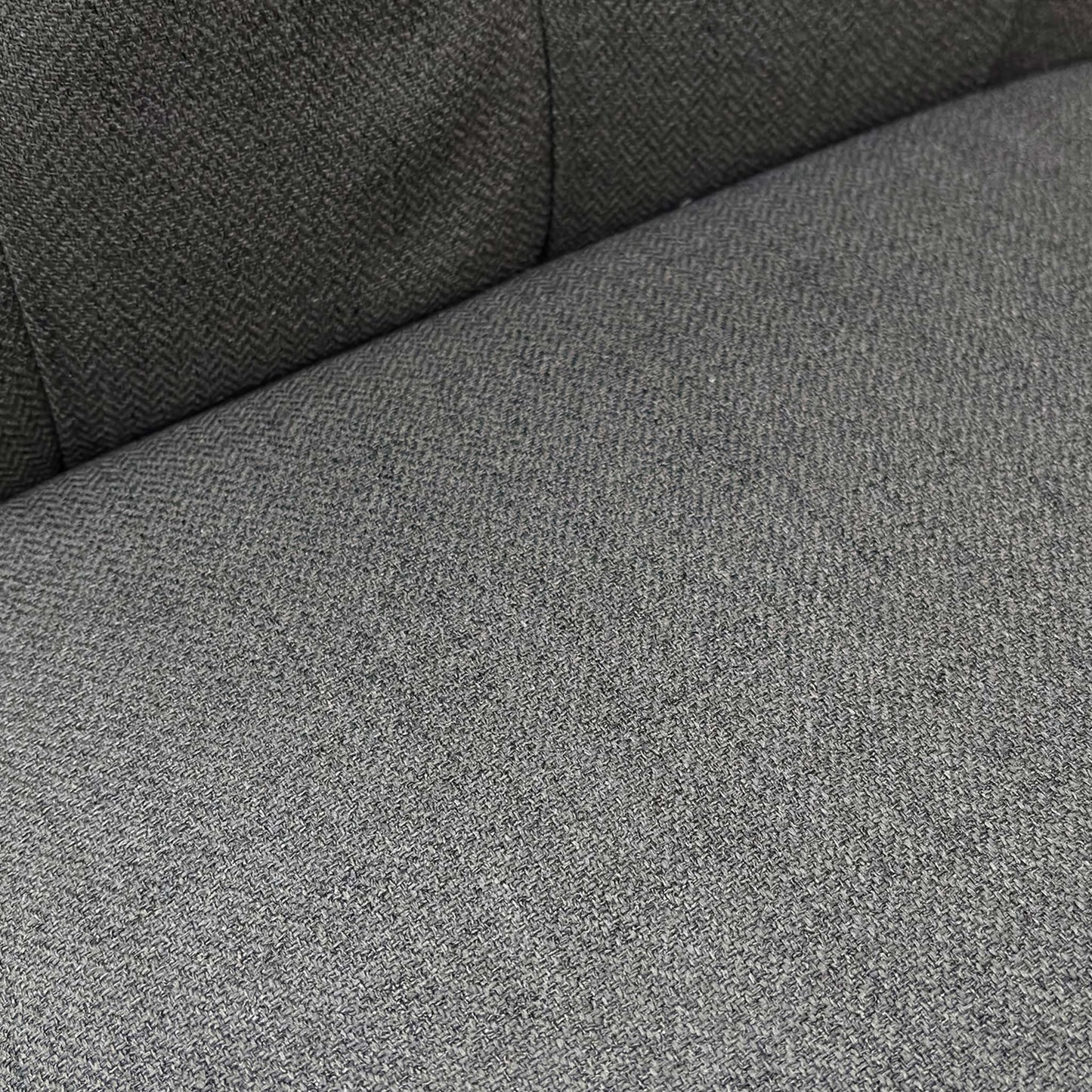 Close-up side profile of the ‘Lewis’ chair showcasing the deep cushioning and distinct scroll-top curve.