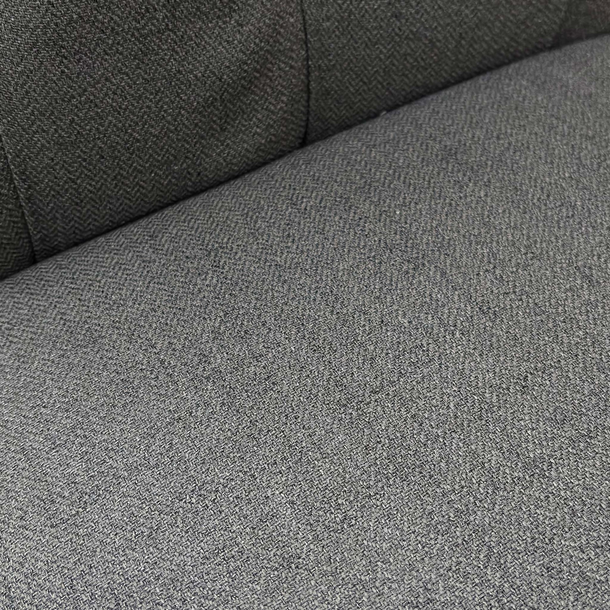 Close-up side profile of the ‘Lewis’ chair showcasing the deep cushioning and distinct scroll-top curve.
