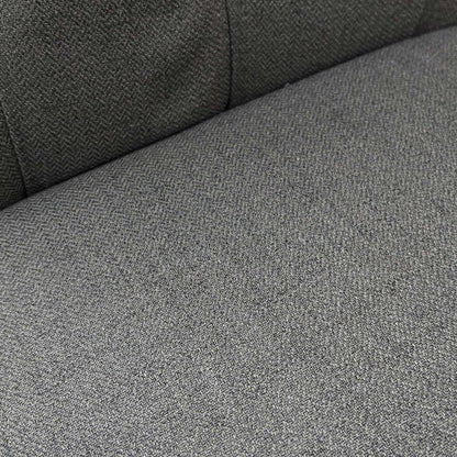 Close-up side profile of the ‘Lewis’ chair showcasing the deep cushioning and distinct scroll-top curve.