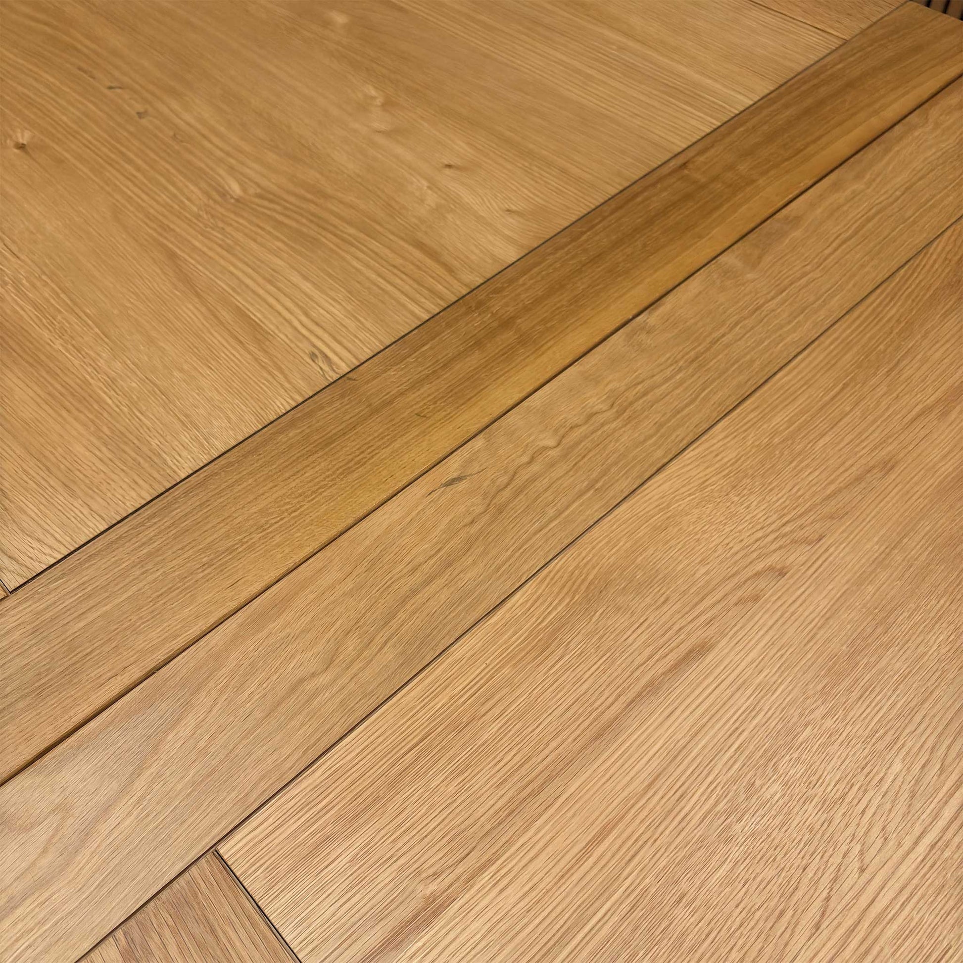 Close-up of the solid oak table top, emphasizing the rich natural texture and high-quality craftsmanship.