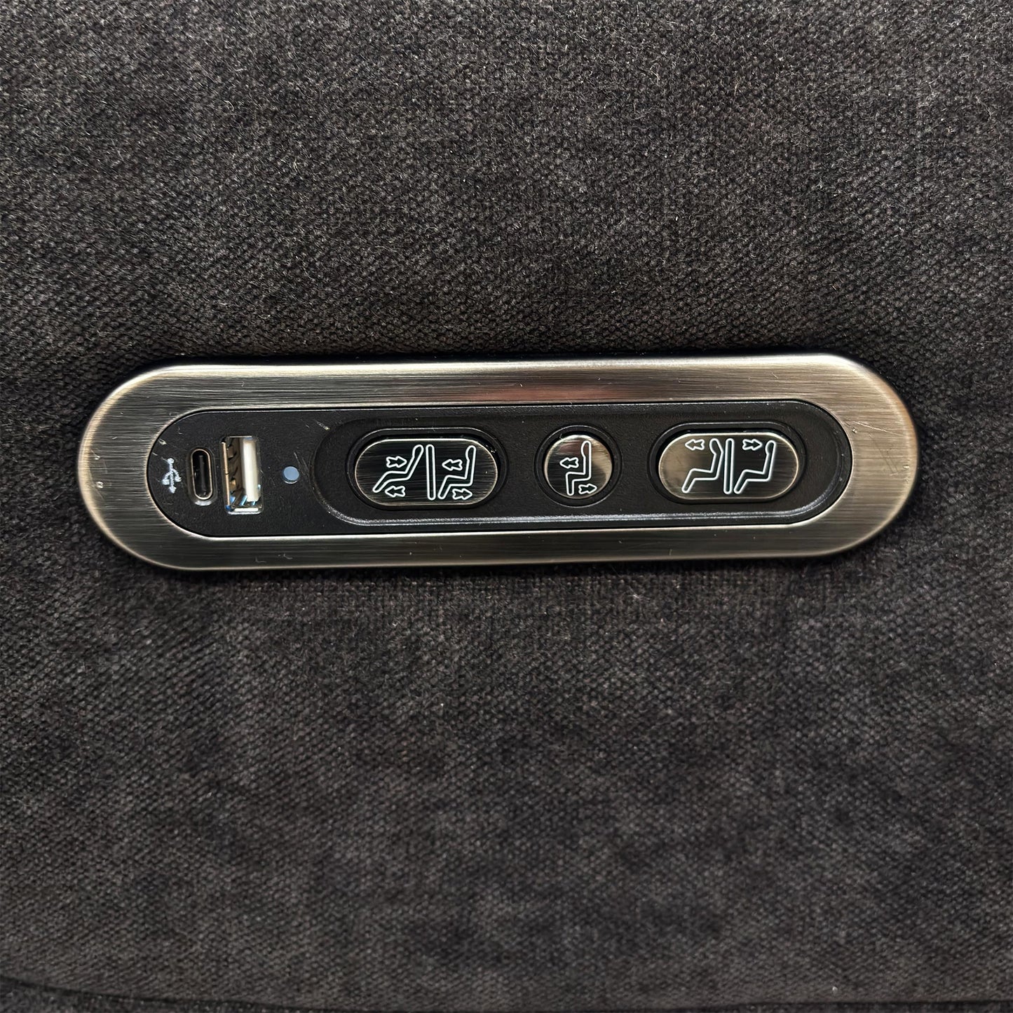 Close-up of the integrated power controls and USB charging port on the side of the sofa armrest.