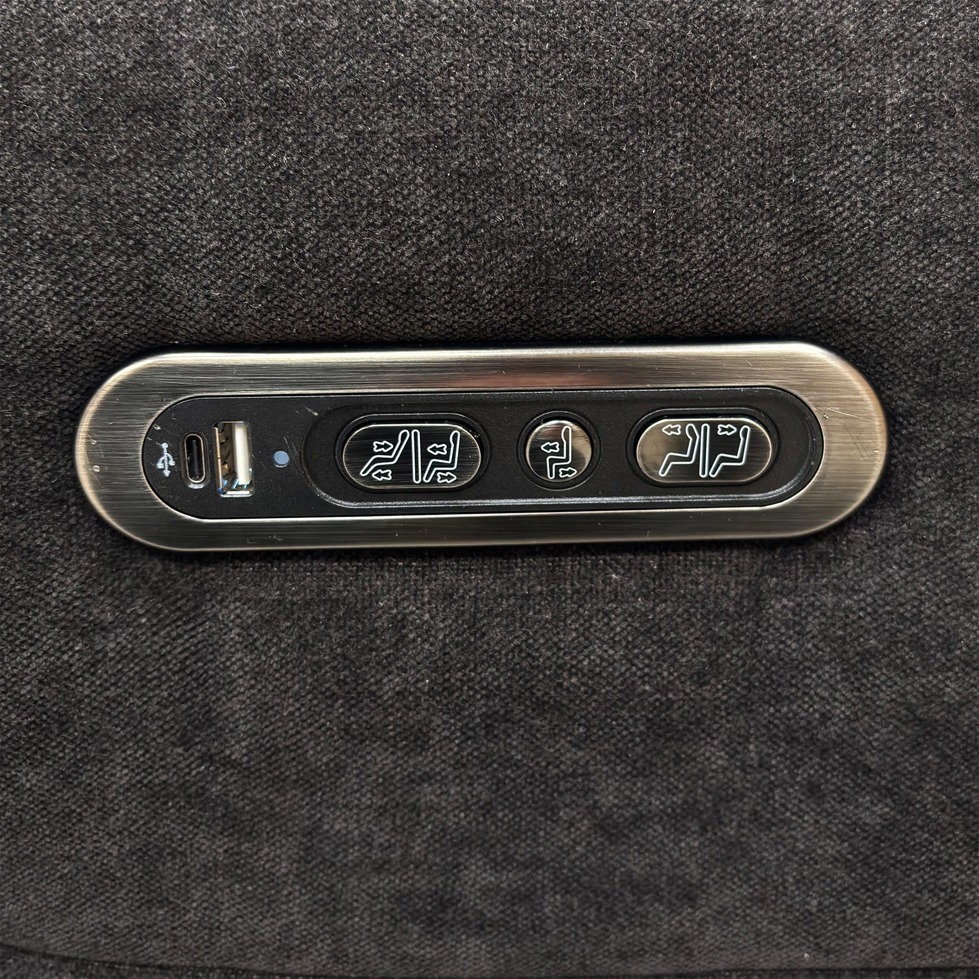Close-up of the integrated power controls and USB charging port on the side of the sofa armrest.