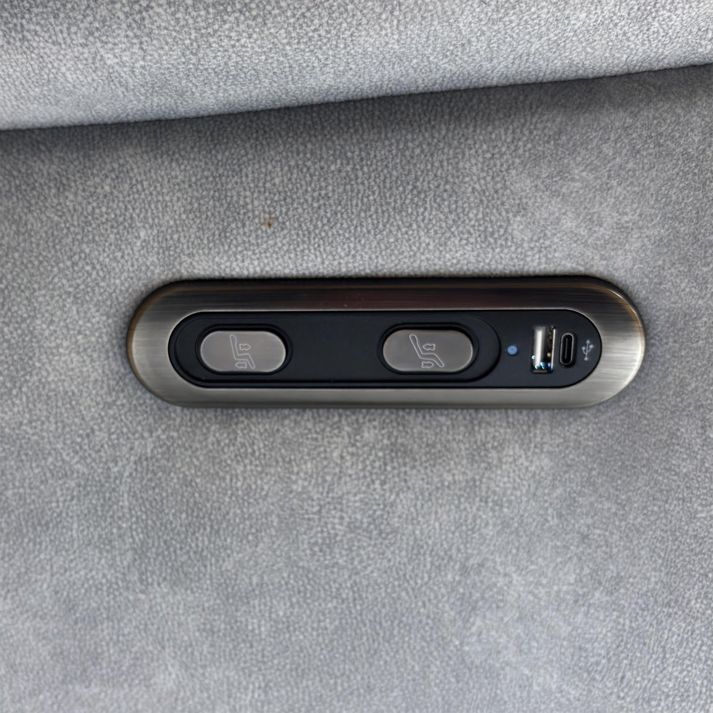 View of the integrated power control panel on the sofa armrest, featuring a safety lock and USB charging ports.