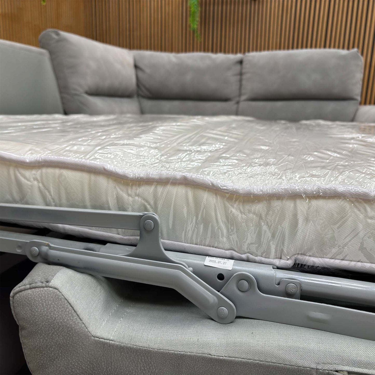 View of the ‘Flex’ Dove Grey fabric sofa with the pull-out bed mechanism fully extended, showing the conversion from corner sofa to bed.