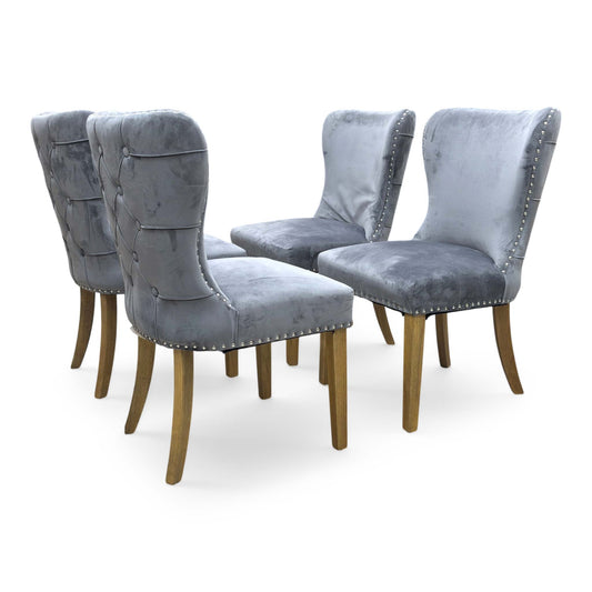 Full view of set of 4 ‘Chennai’ fixed dining chairs in Grey Luxe Velvet, featuring a classic roll-top backrest, elegant silver stud detailing, and black wooden legs.