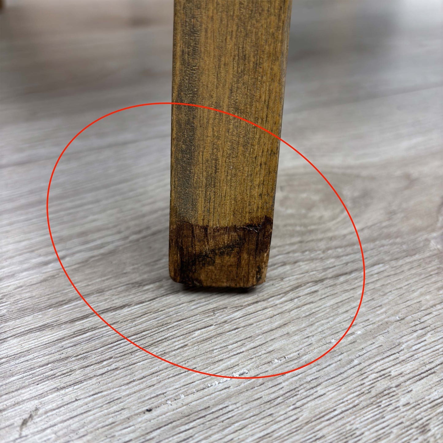 Detail shot of the black solid wood legs, showing the tapered design and the protective floor glides on the base of the chair.
