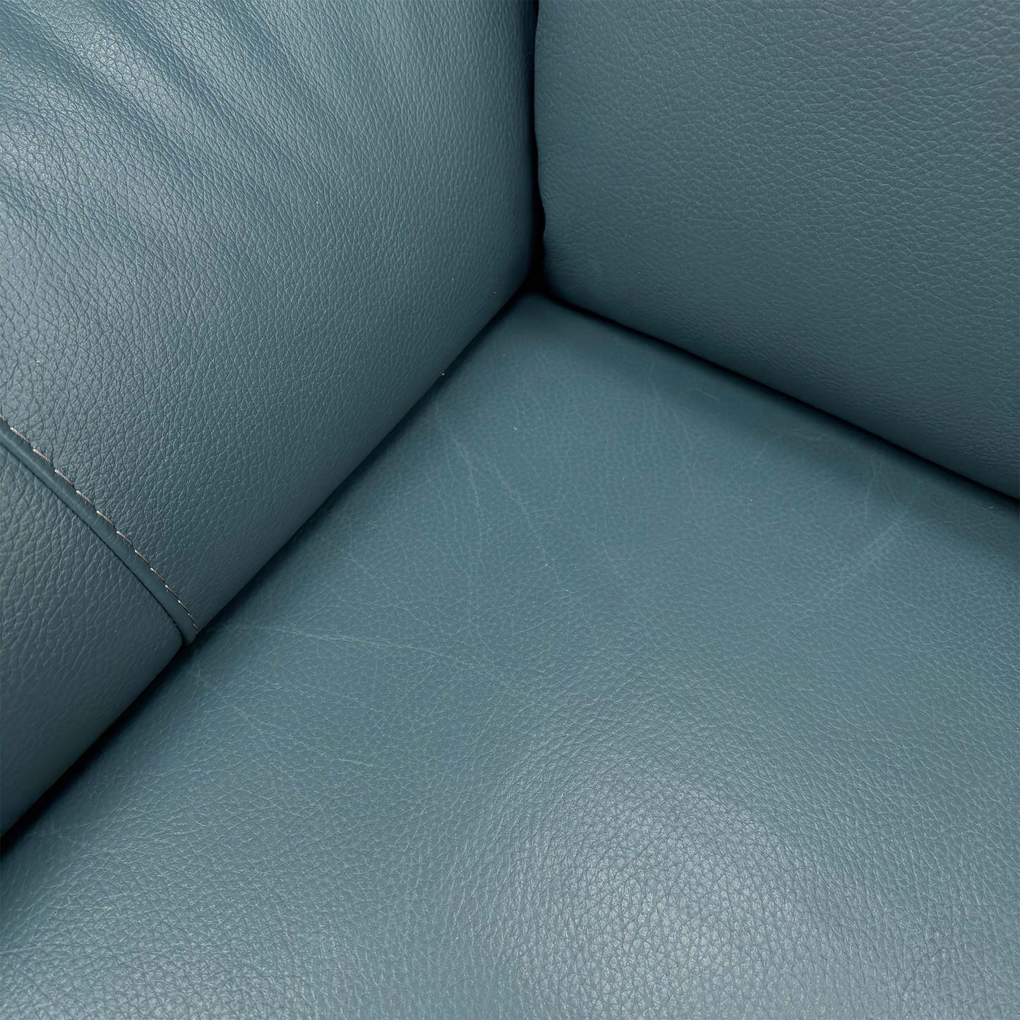 Close-up of the Midnight Jade matte leather upholstery, highlighting the high-quality grain, soft-touch texture, and premium tonal stitching.
