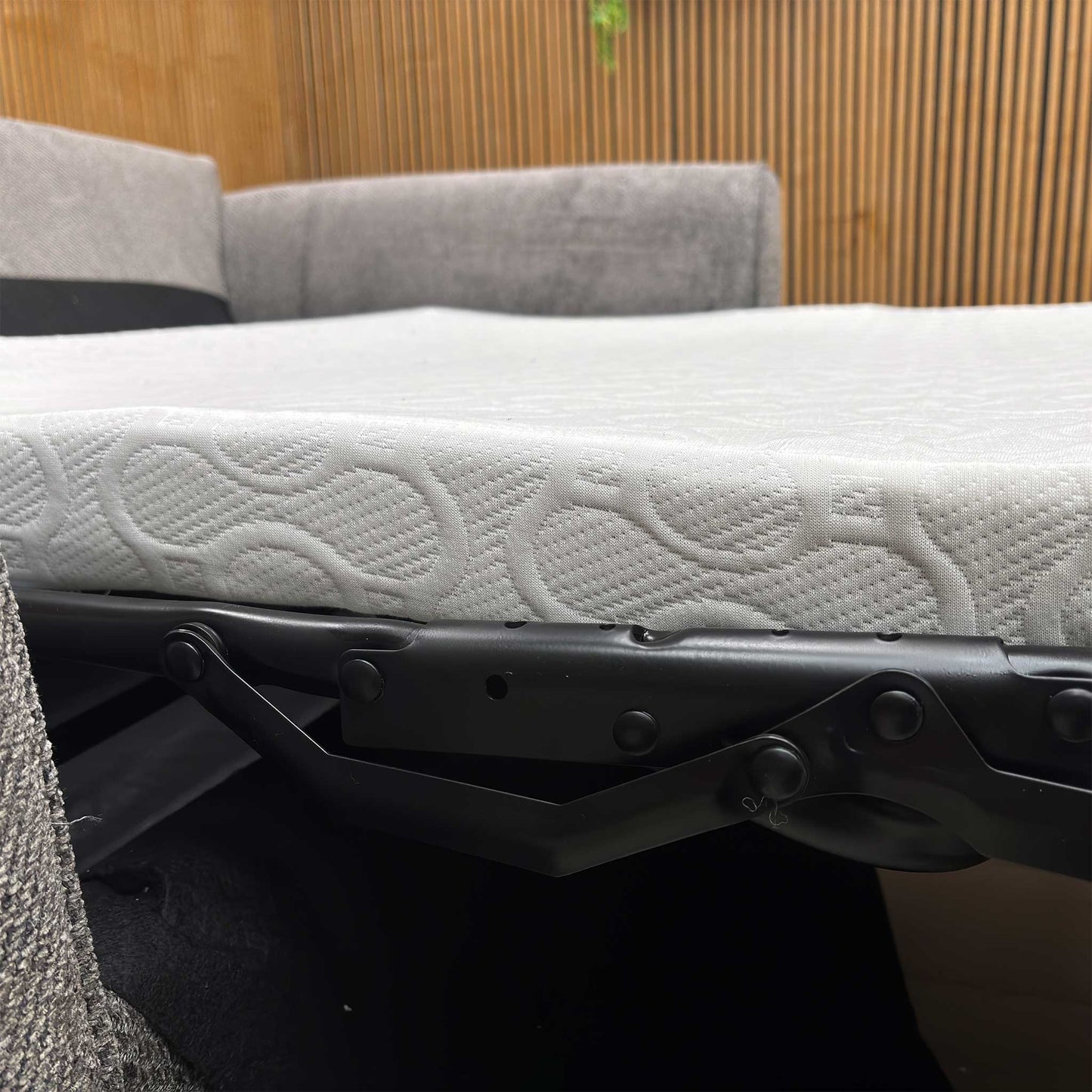 Detail shot of the sleek sofa feet and the integrated pull-out handle, showing the practical design and high-quality finish of the Sophie model.