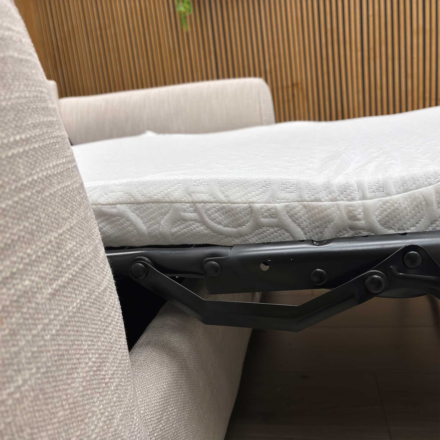 Detailed shot of the curved, padded armrest of the Roma grey linen sofa bed for enhanced comfort.