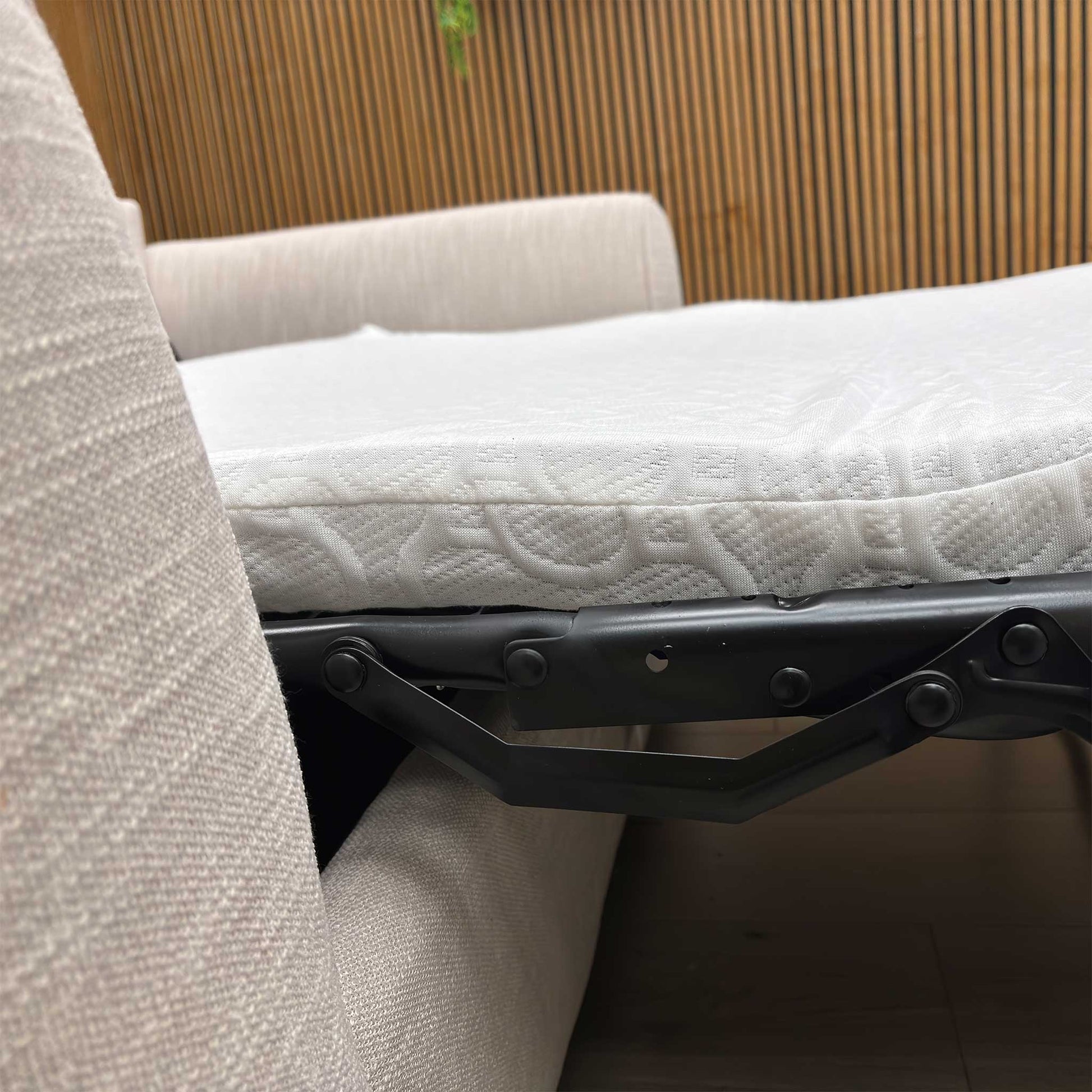 Detailed shot of the curved, padded armrest of the Roma grey linen sofa bed for enhanced comfort.