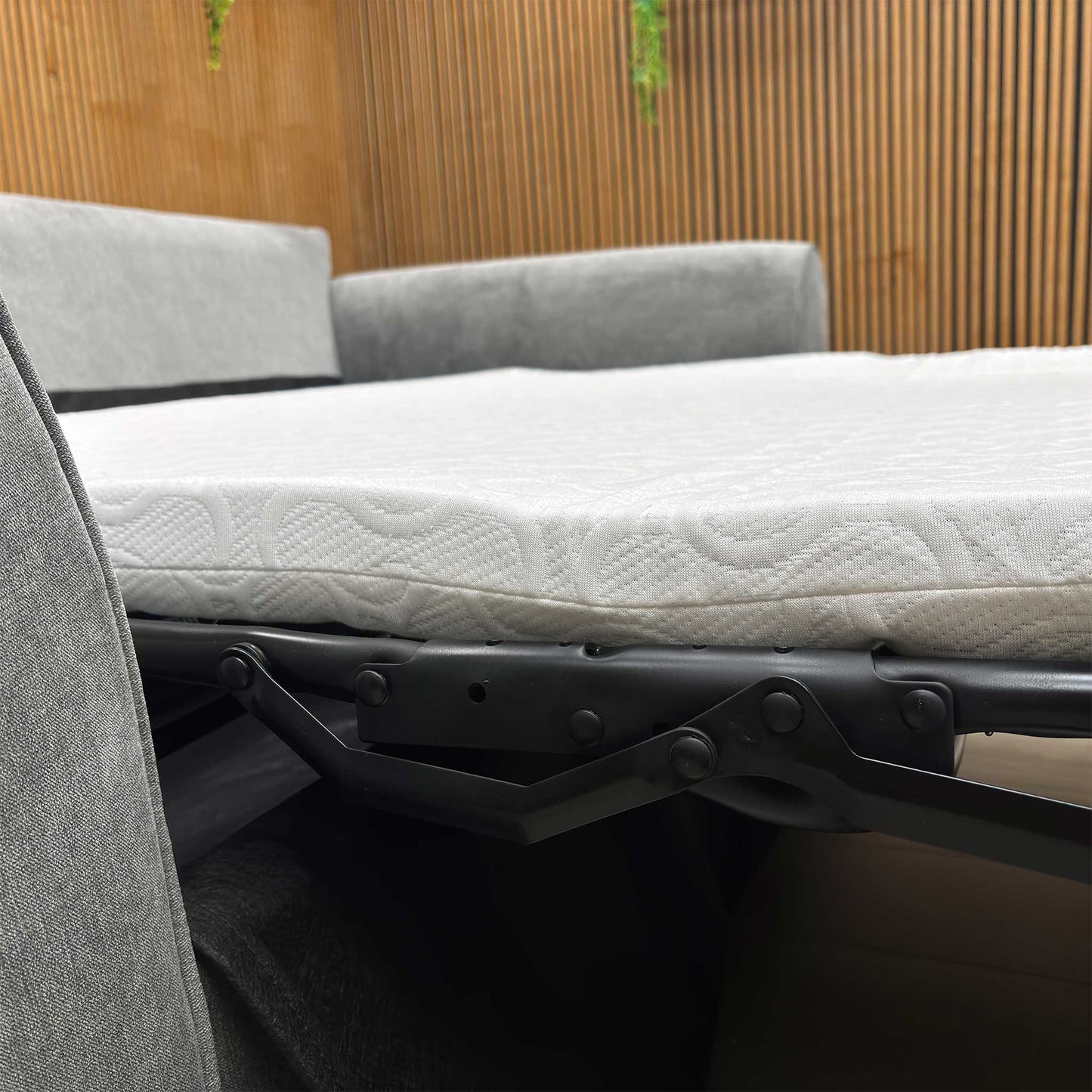 Detailed shot of the curved, padded armrest of the Roma grey linen sofa bed for enhanced comfort.