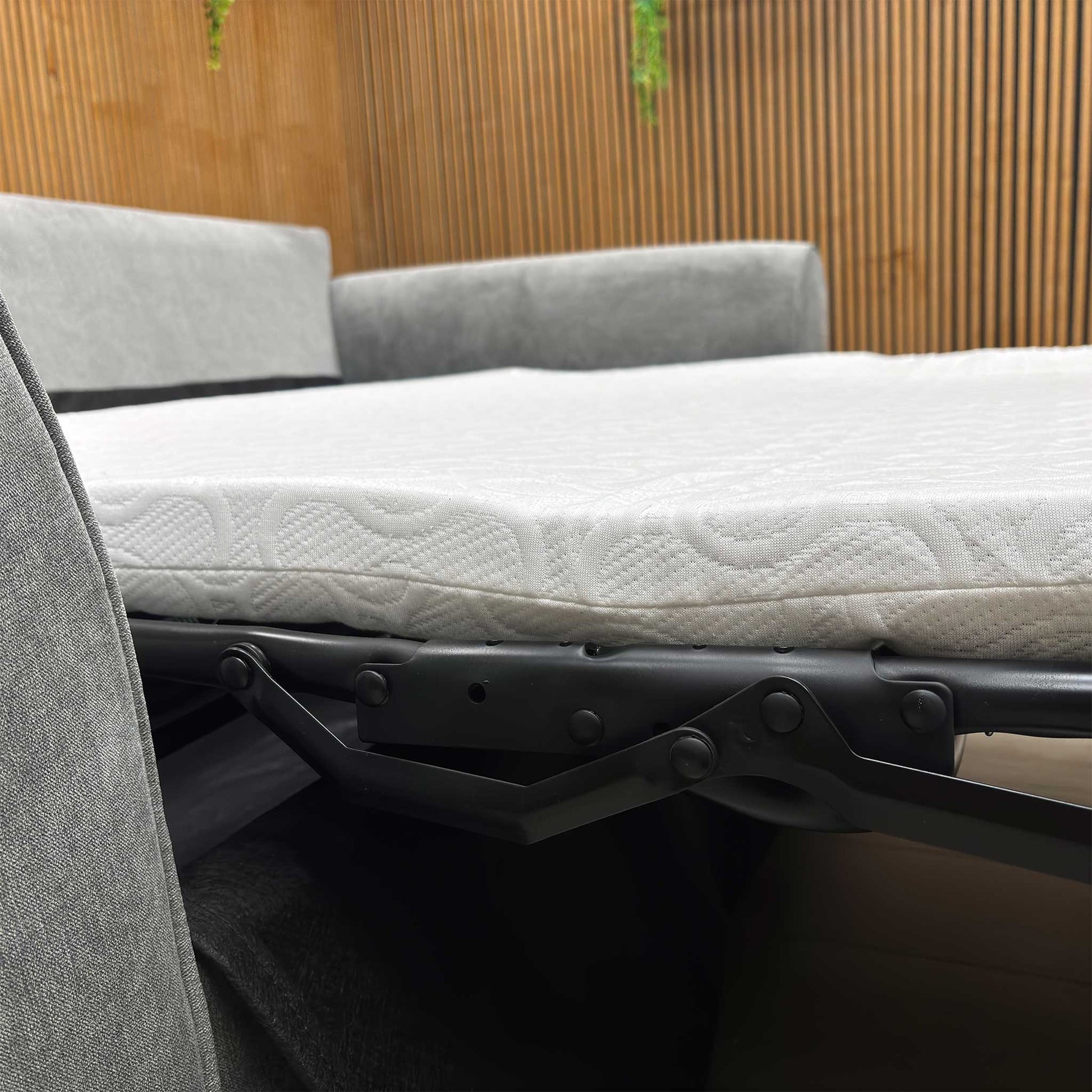 Detailed shot of the curved, padded armrest of the Roma grey linen sofa bed for enhanced comfort.