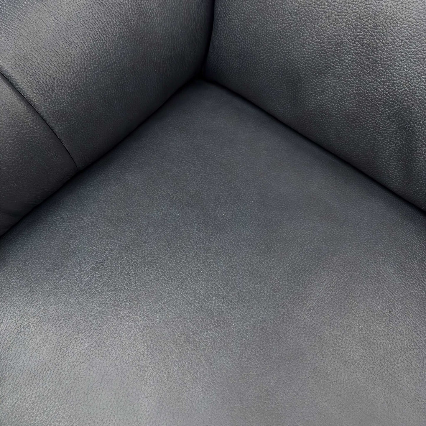 Close-up of the soft 100% Jet Black leather upholstery, highlighting the piped edges, understated buttoning, and high-quality grain.