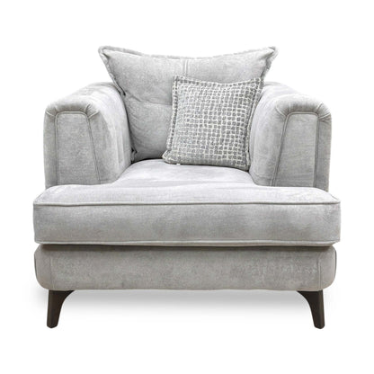 Front profile of the Farrah armchair, emphasizing the graceful angle of the backrest and the tailored finish of the silver fabric upholstery.