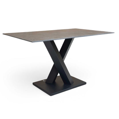 Full view of Compact 135cm Warrior dining table featuring a grey sintered stone ceramic top and a bold dark grey V-shaped metal base.
