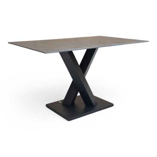 Full view of Compact 135cm Warrior dining table featuring a grey sintered stone ceramic top and a bold dark grey V-shaped metal base.